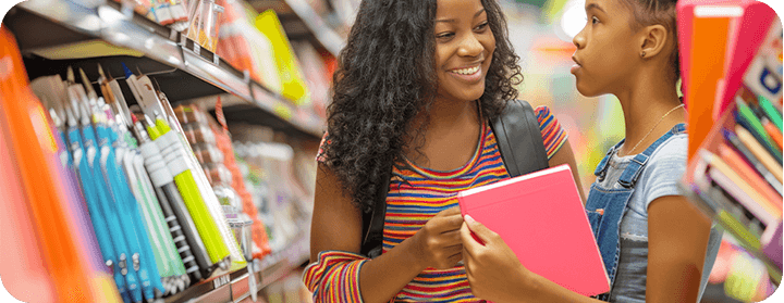 Mãe e filha comprando material de escolar